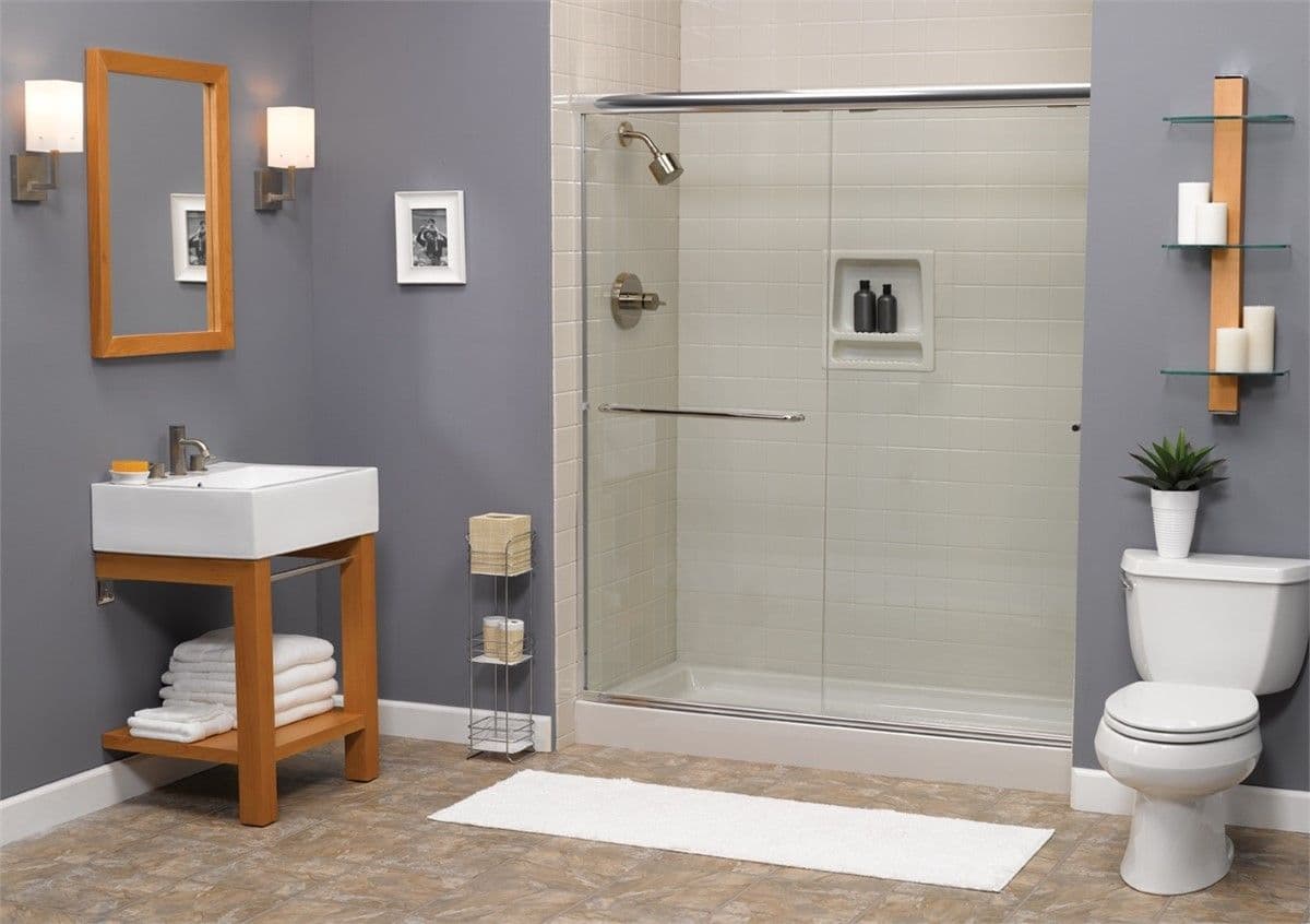A cozy home bathroom with a modern shower and frameless glass dooors